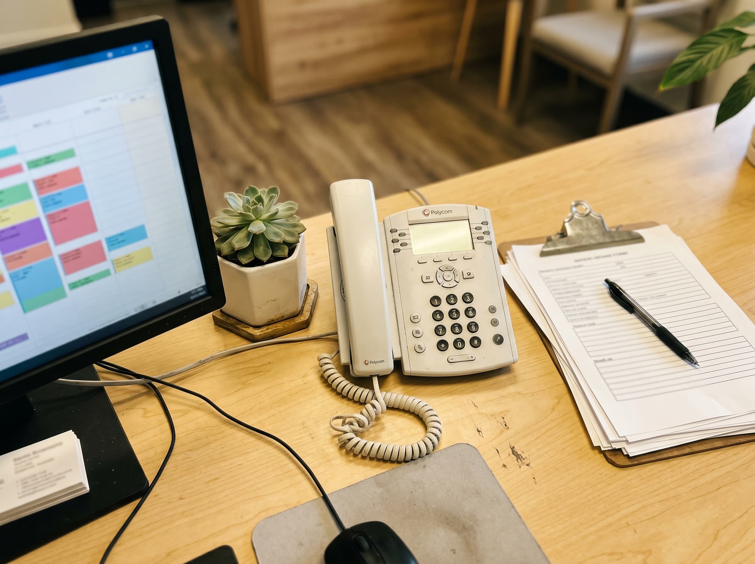 Receptiebalie van een fysiotherapiepraktijk met telefoon en agenda